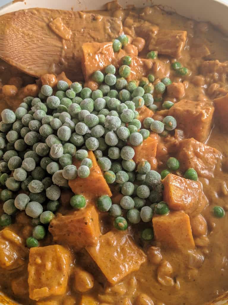 Vegan Chickpea and Pumpkin Korma Curry adding peas